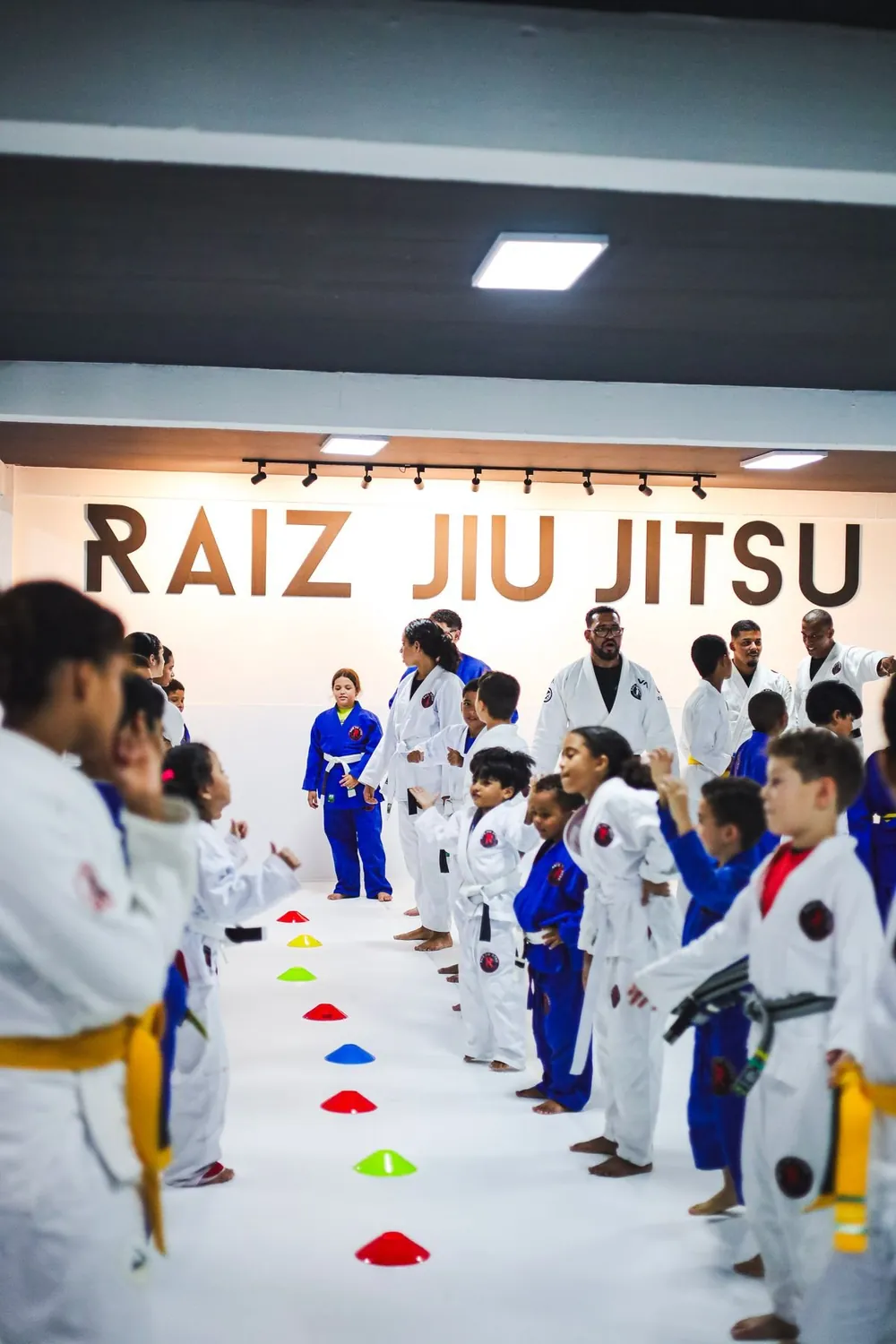 Crianças de kimono perfiladas no tatame do CT Raiz Jiu-Jitsu 46