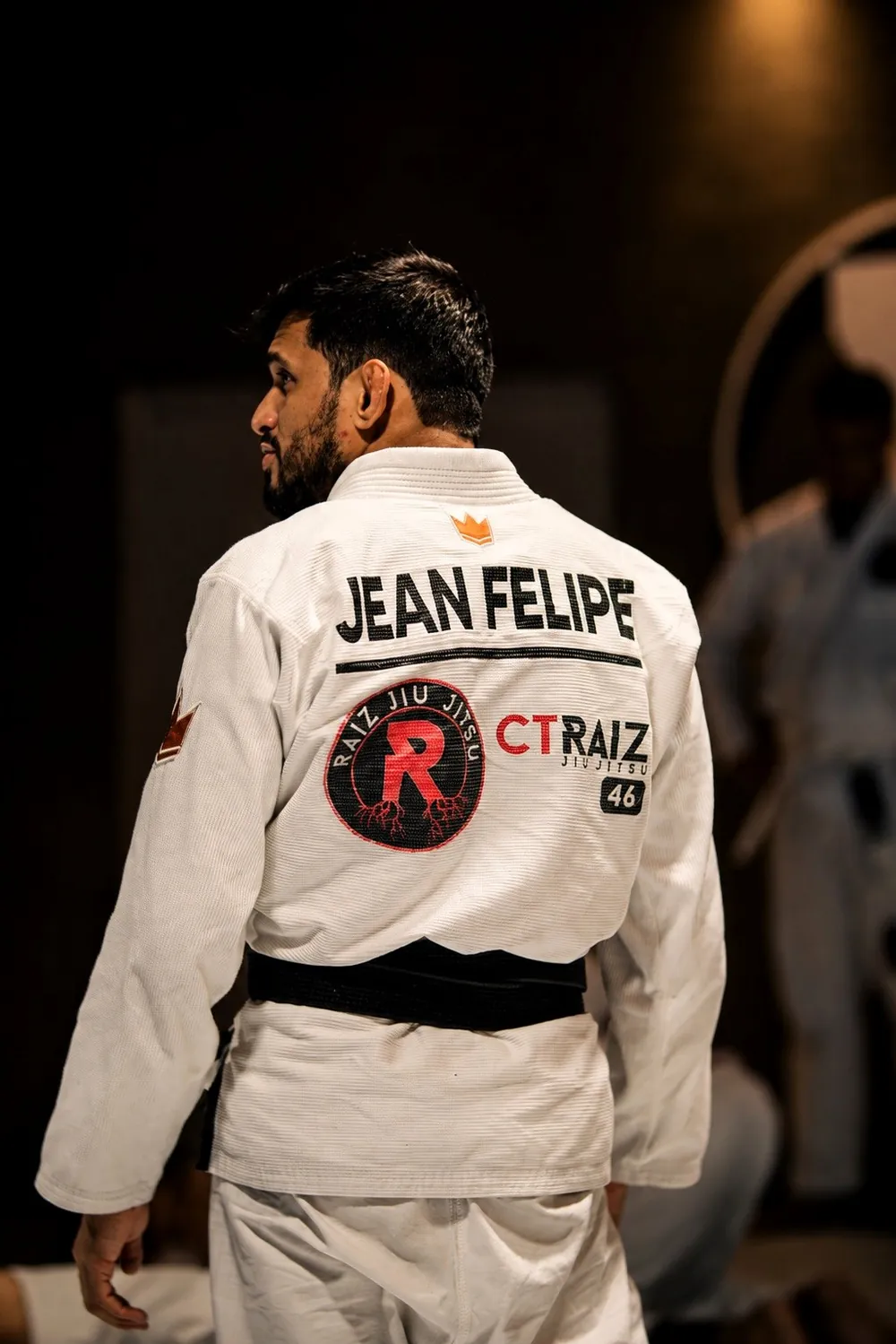 Professor faixa-preta do CT Raiz Jiu-Jitsu 46 de kimono branco no tatame