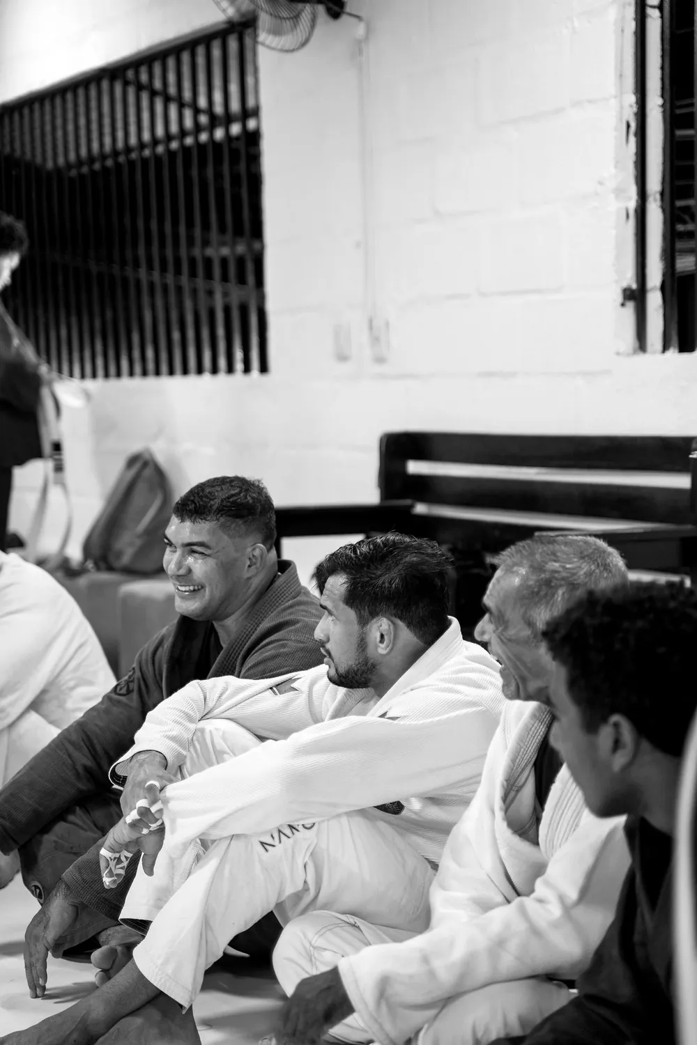 Pequeno grupo de alunos de kimono sentados no tatame do CT Raiz Jiu-Jitsu 46